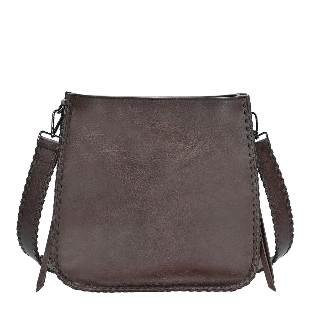 Brown leather whipstitch crossbody bag featuring adjustable strap and stitched edges