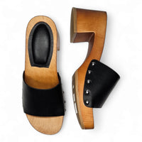 Pair of wooden open toe clogs featuring black leather straps and studded accents