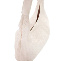 White ballet pointe shoe with satin ribbons beside a Woven Faux Leather Tote Bag