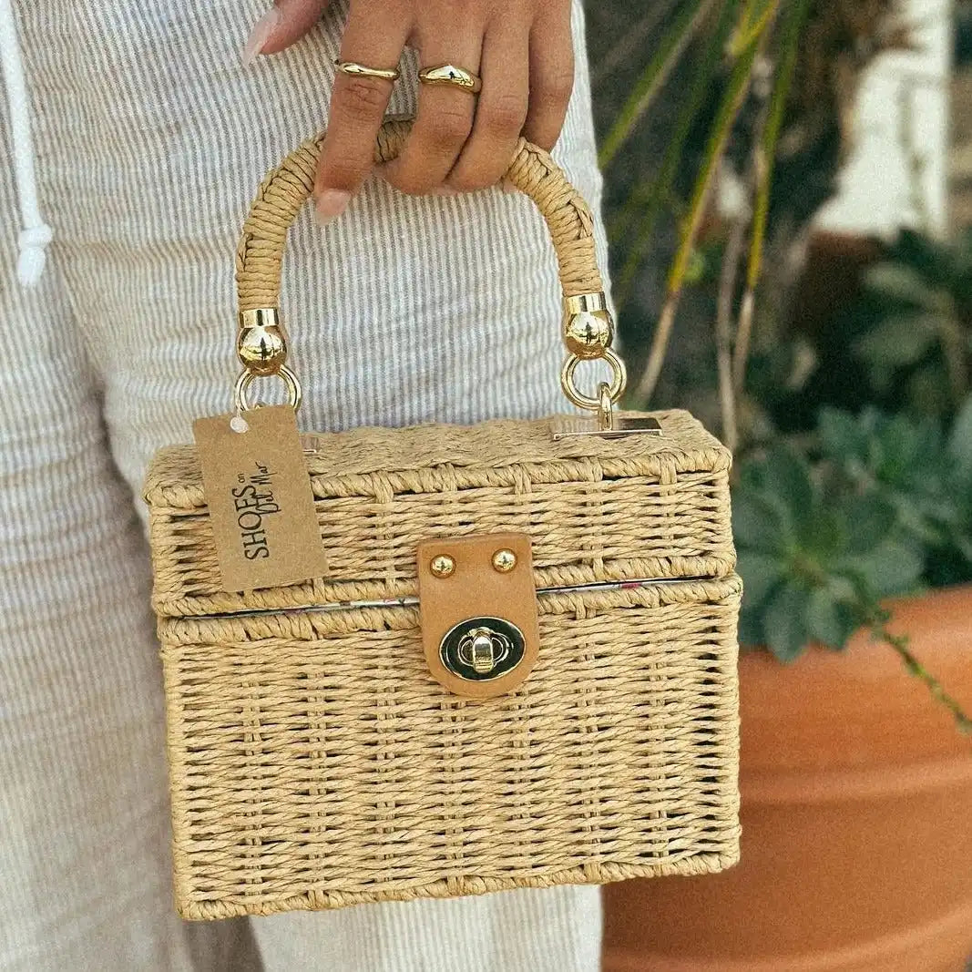 Woven straw box purse with bamboo handles and a gold clasp.