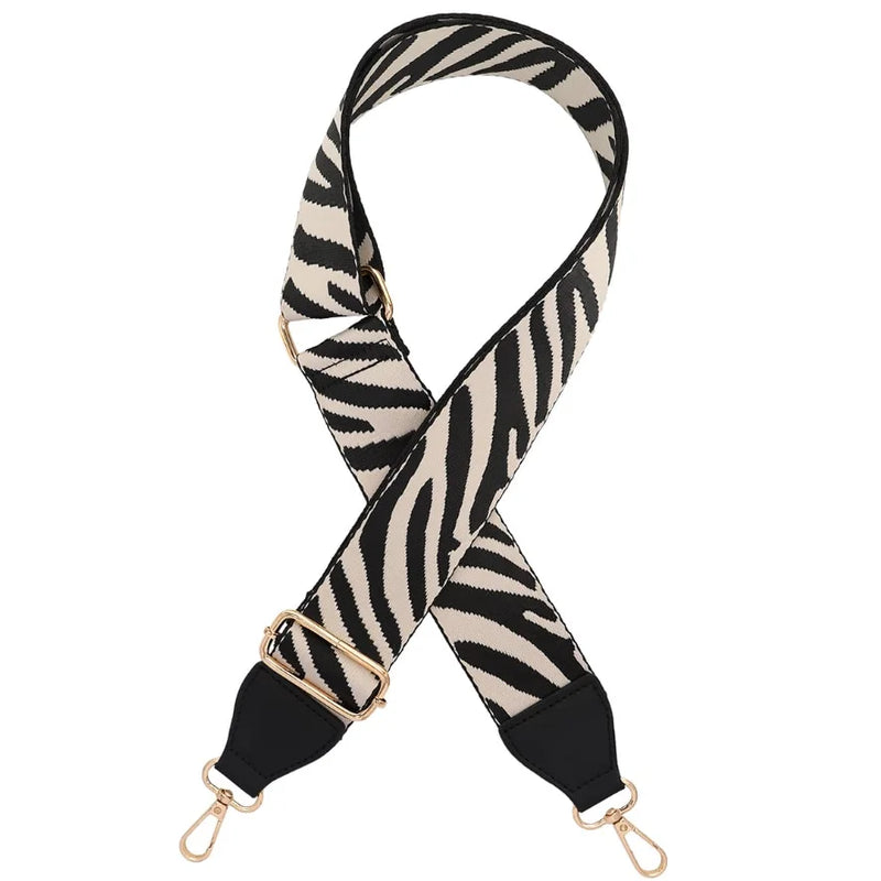 Zebra-print shoulder strap with gold hardware for a stylish guitar bag